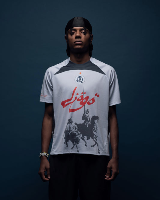 High-performance graphic football jersey made from 100% polyester. Designed with finer side panels to enhance breathability during intense activity. Features a fully embroidered club logo on the chest and sublimated graphics for long-lasting visual detail. DON QUIJOTE